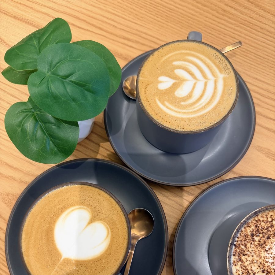 Two lattes with latte art on a wooden table